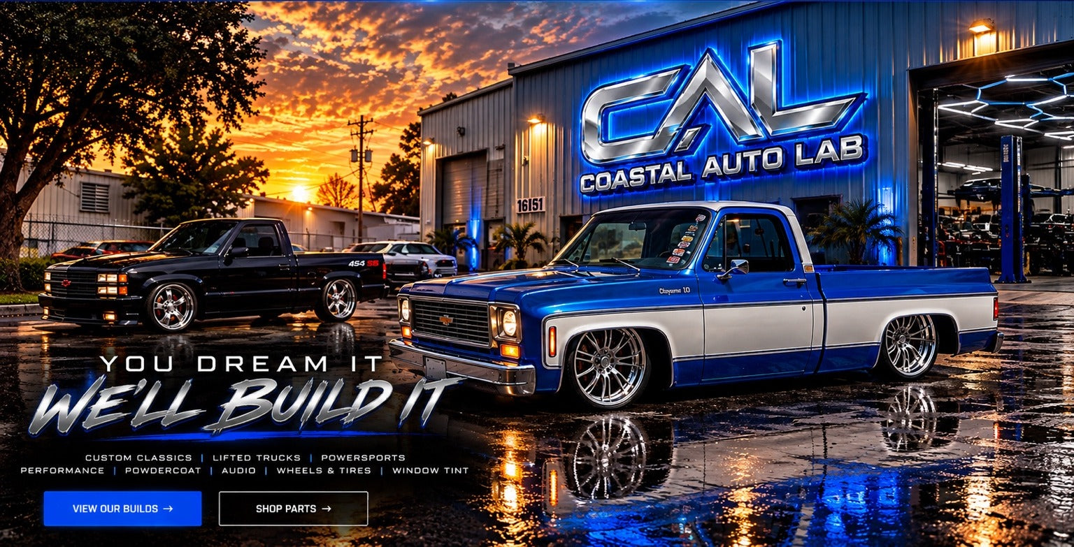 Coastal Auto Lab glowing blue shop sign at sunset with a black Chevrolet 454 SS and blue and white classic C10